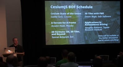 A man standing in front a a presentation on a large screen